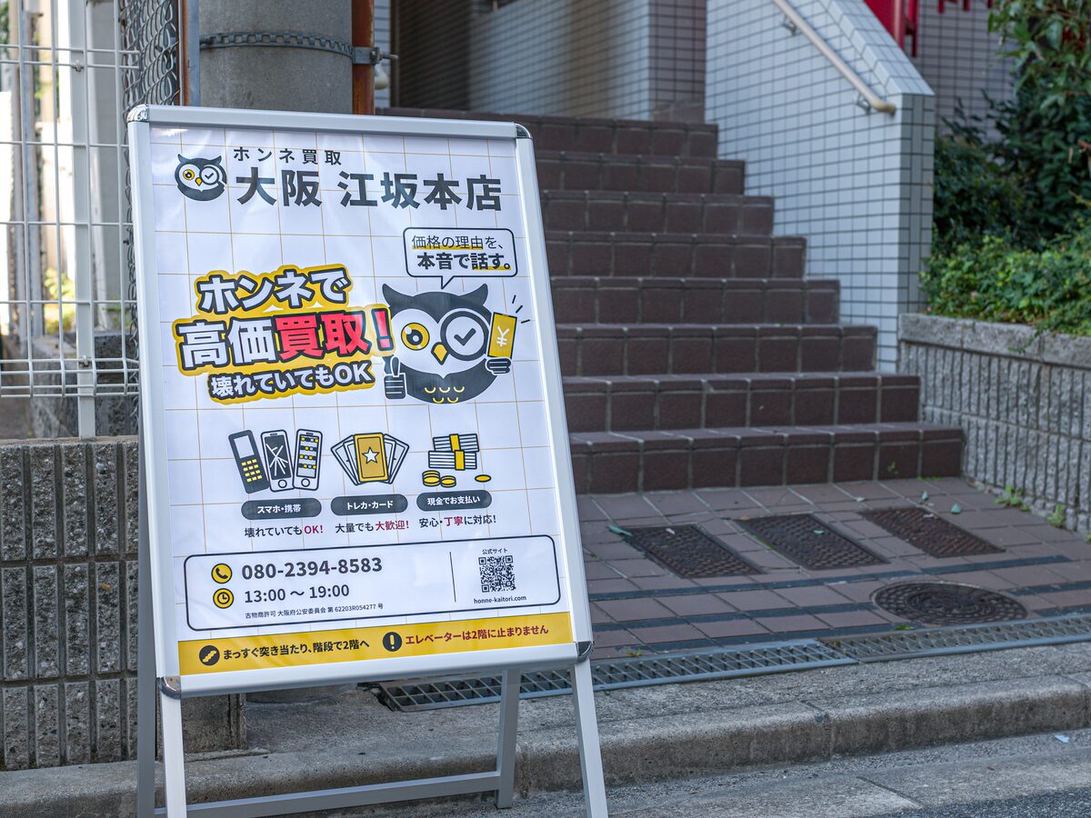 Our "Honne Kaitori Osaka Esaka" stand sign in front of the entrance steps of the building.