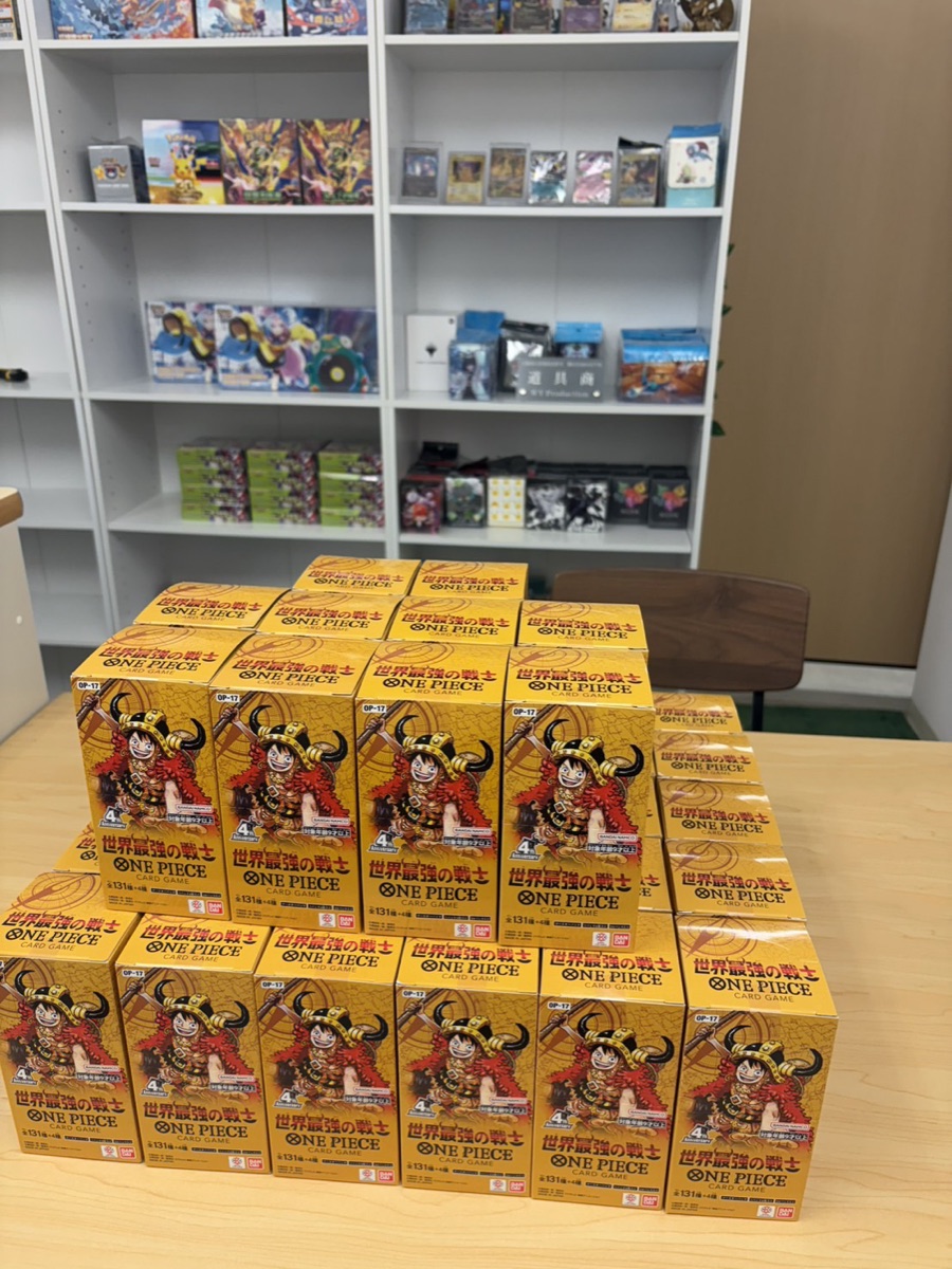 ホンネ買取の店内で机に積み上げたワンピースカード「世界最強の戦士(OP-17)」のBOX